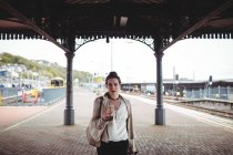 Retrato de mulher bonita de pé na plataforma estação ferroviária — Fotografia de Stock