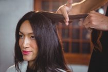Hairdresser styling customer hair in salon — Stock Photo