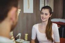 Paciente femenina hablando con terapeuta masculina en clínica - foto de stock