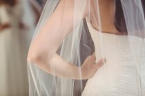Frauenmitte probiert Hochzeitskleid im Geschäft an — Stockfoto