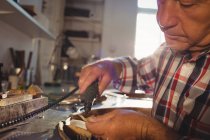 Aufmerksame Goldschmiedin mit Handstückmaschine in Werkstatt — Stockfoto