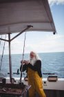 Pescador ajustando anzuelo de pesca en barco de pesca - foto de stock