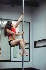 Привабливі полюс танцюрист практикуючих полюс танці в фітнес-студія — стокове фото