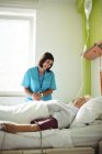 Krankenschwester tröstet Seniorin auf Krankenhausstation — Stockfoto