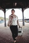 Junge Frau benutzt Handy am Bahnsteig — Stockfoto