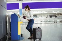 Путешественник с помощью автомата самообслуживания в аэропорту — стоковое фото