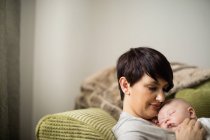 Nahaufnahme von Baby, das auf Mutter im heimischen Wohnzimmer schläft — Stockfoto