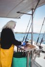 Side view of Fisherman filleting fish on boat — Stock Photo