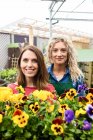 Портрет двох жінок-квіточок, що посміхаються в садовому центрі — стокове фото