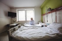 Mulher idosa sentada na cama na enfermaria do hospital — Fotografia de Stock