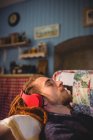 Giovane hipster uomo ascoltare musica mentre si rilassa sul divano a casa — Foto stock
