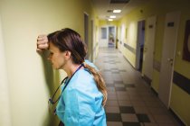 Депрессивная медсестра, стоящая в коридоре больницы — стоковое фото