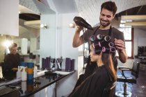 Sorrindo cabeleireiro masculino styling clientes cabelo no salão — Fotografia de Stock