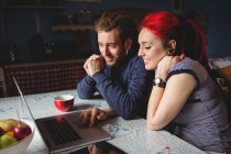 Smiling hipster couple using laptop at home — Stock Photo