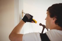 Carpinteiro trabalhando na moldura da porta em casa — Fotografia de Stock