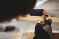 Carpinteiro usando medidor de marcação na porta de madeira em casa — Fotografia de Stock