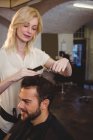Homem recebendo seu cabelo aparado no salão de cabeleireiro — Fotografia de Stock