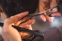 Abgeschnittenes Bild einer Frau, die sich im Salon die Haare schneiden lässt — Stockfoto