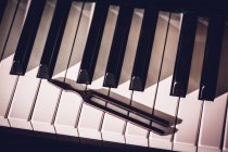 Primo piano dello strumento di riparazione mantenuto sulla vecchia tastiera del pianoforte — Foto stock