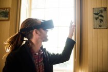 Primer plano del gesto hipster mientras se utiliza el simulador de realidad virtual en casa - foto de stock