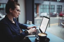 Junge Geschäftsfrau benutzt Laptop in Café — Stockfoto
