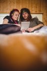 Hipster-Paar nutzt digitales Tablet beim Entspannen im heimischen Bett — Stockfoto