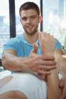 Male physiotherapist giving arms massage to female patient in clinic — Stock Photo
