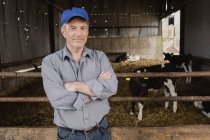 Portrait d'un agriculteur confiant debout près d'une clôture à la grange — Photo de stock