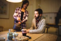 Close-up of cookie on a table with couple in background at home — Stock Photo