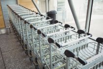 Trolleys kept in a row in airport terminal — Stock Photo