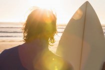 Surfista olhando para o mar na praia — Fotografia de Stock