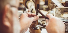Горолог ремонтує кишеньковий годинник у майстерні — стокове фото