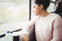 Smart woman looking through window while sitting in train — Stock Photo