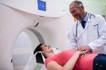 Smiling doctor consoling patient before mri scanning at hospital — Stock Photo