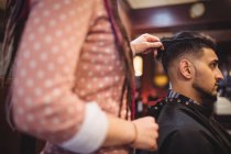 Homem recebendo seu cabelo aparado na barbearia — Fotografia de Stock