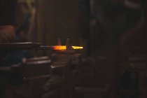 Hand des Schmieds arbeitet in der Werkstatt an einer erhitzten Eisenstange — Stockfoto