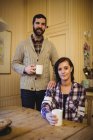 Пара тримає чашки кави вдома — стокове фото