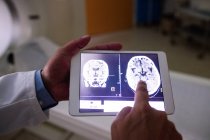 Médico examinando ressonância magnética cerebral em tablet digital no hospital — Fotografia de Stock