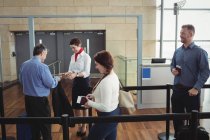 Homme d'affaires montrant sa carte d'embarquement au comptoir d'enregistrement à l'aéroport — Photo de stock