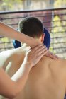 Physiothérapeute féminine donnant massage du dos à un patient masculin à la clinique — Photo de stock