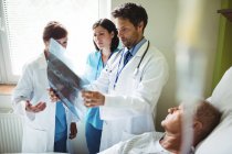 Лікарі взаємодіючих над рентгенівського звіт з пацієнта у лікарні — стокове фото