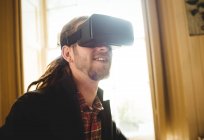 Primer plano del hombre utilizando el simulador de realidad virtual en casa - foto de stock