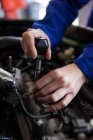 Image recadrée de mécanicien entretien moteur de voiture au garage de réparation — Photo de stock