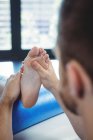 Fisioterapeuta masculino dando massagem nos pés para paciente do sexo feminino na clínica — Fotografia de Stock
