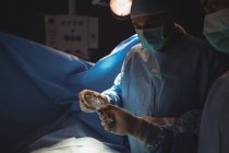 Cirurgiões do sexo masculino discutindo enquanto a operação na sala de operação no hospital — Fotografia de Stock