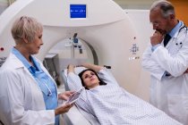 Врачи разговаривают с пациентом перед сканированием в больнице — стоковое фото
