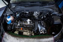 Auto con cappuccio aperto per la manutenzione in officina di riparazione — Foto stock