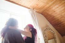 Jovem casal hipster em pé à janela em casa — Fotografia de Stock