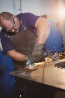 Schweißer sägt Metall mit Elektrowerkzeug in Werkstatt — Stockfoto
