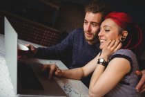 Feliz pareja hipster utilizando el ordenador portátil en casa - foto de stock
